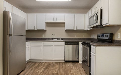 a kitchen with stainless steel appliances and white cabinets