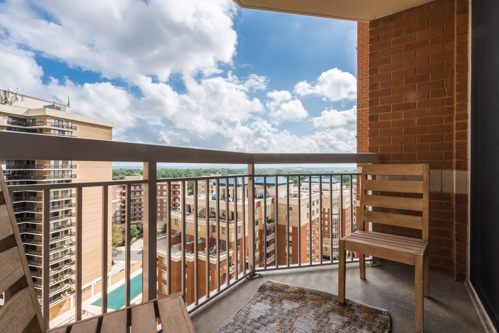 a balcony with a view of a pool and a city