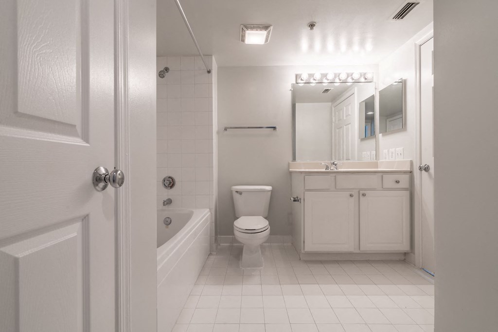 a white bathroom with a toilet and a tub and a sink