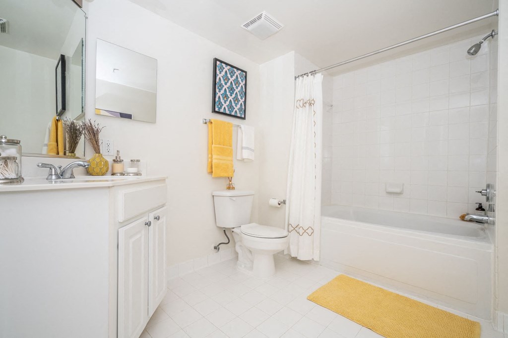 a white bathroom with a shower toilet and sink