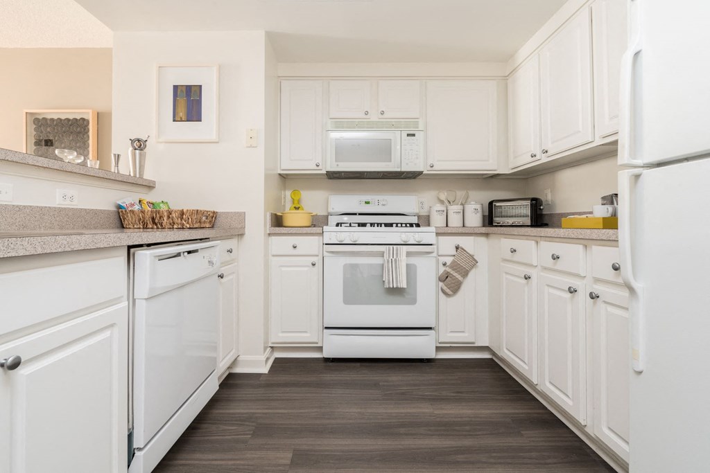 a white kitchen with a stove and a microwave
