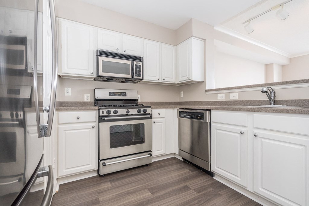 a kitchen with white cabinets and stainless steel appliances