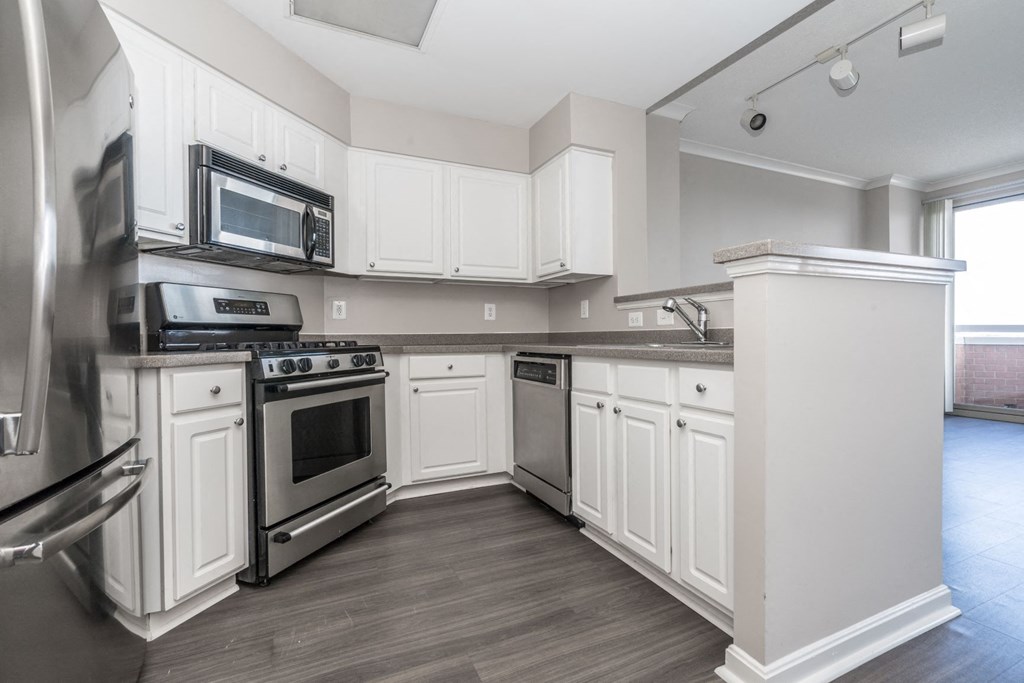 a kitchen with white cabinets and stainless steel appliances