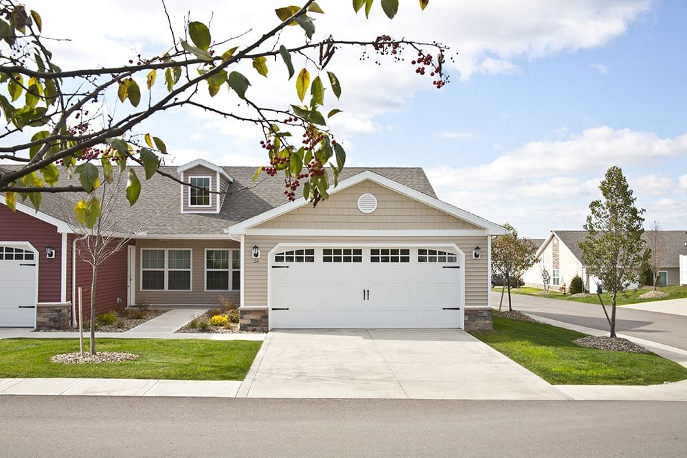 a house with a white garage door in front of a lawn