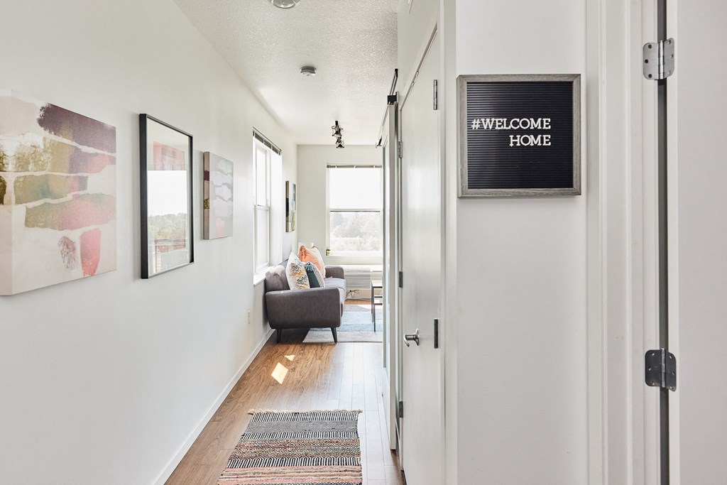 a long hallway with a couch and a chair and a television on the wall