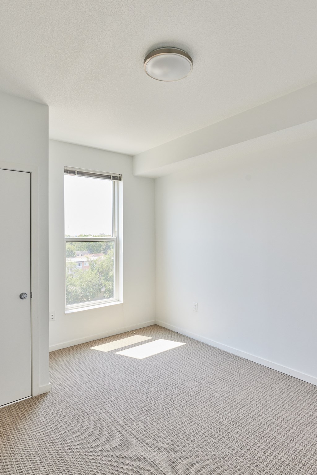 an empty room with a window and a door