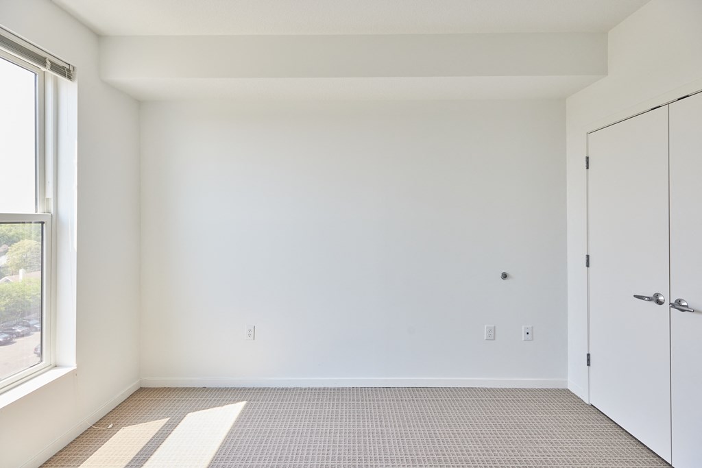 an empty room with white walls and a window