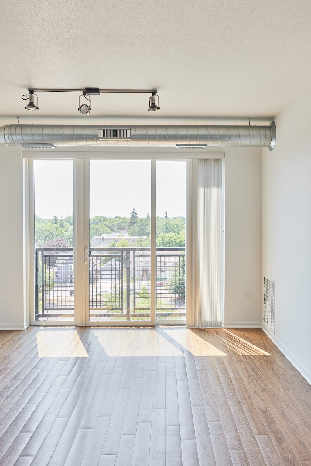 an empty living room with sliding glass doors and a balcony