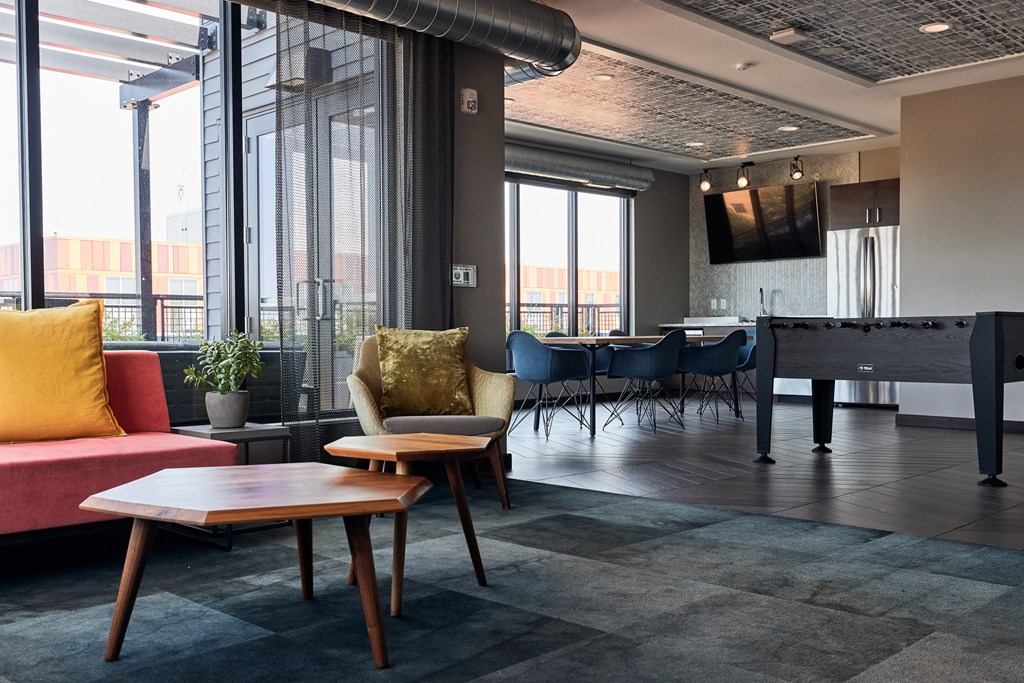 a living room with a piano and tables and chairs