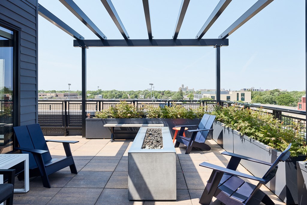 a rooftop patio with tables and chairs and a view of the city