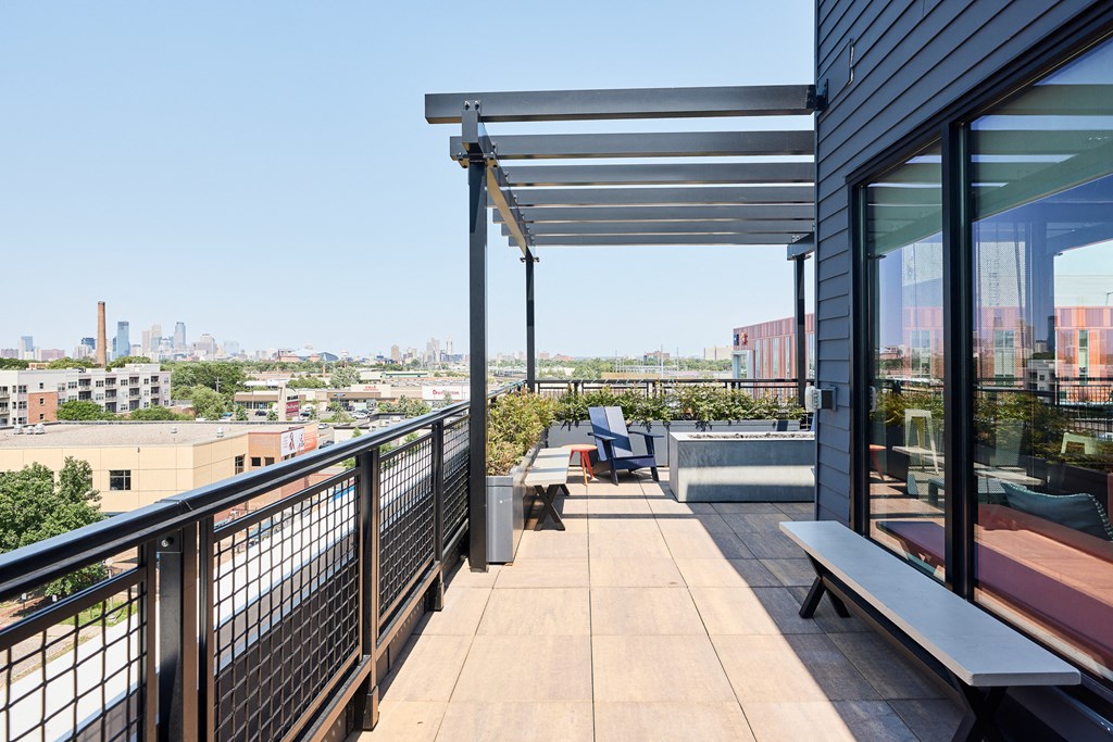 a communal terrace with benches and a view of the city