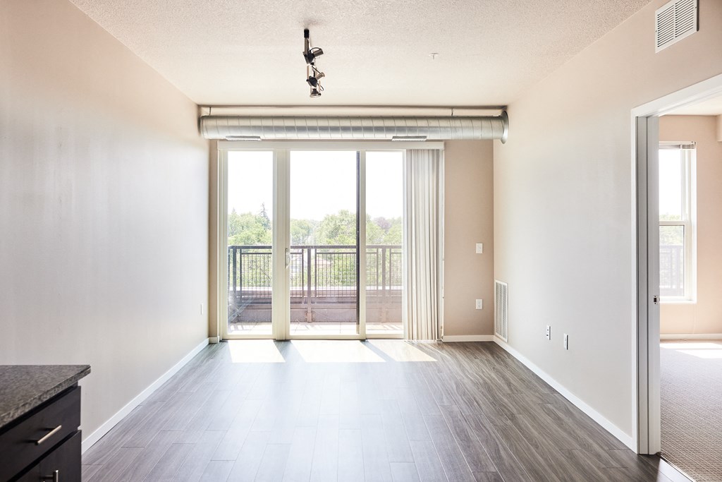 an empty living room with sliding glass doors to a balcony