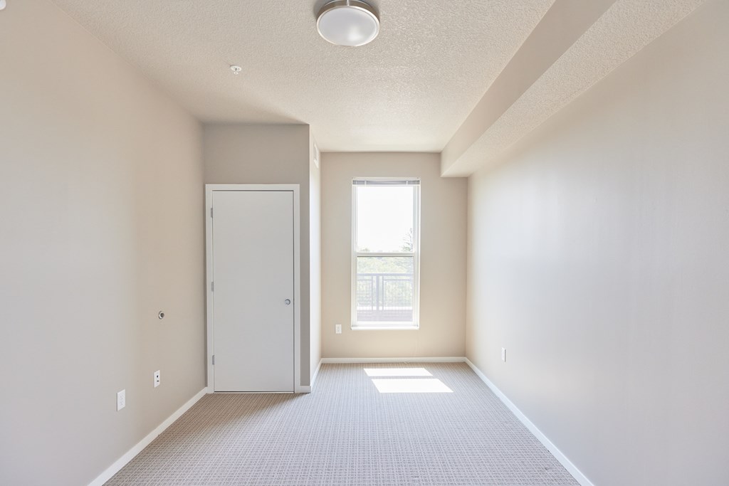 an empty room with a door and a window