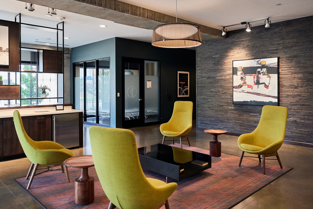 a living room with yellow chairs and a black coffee table