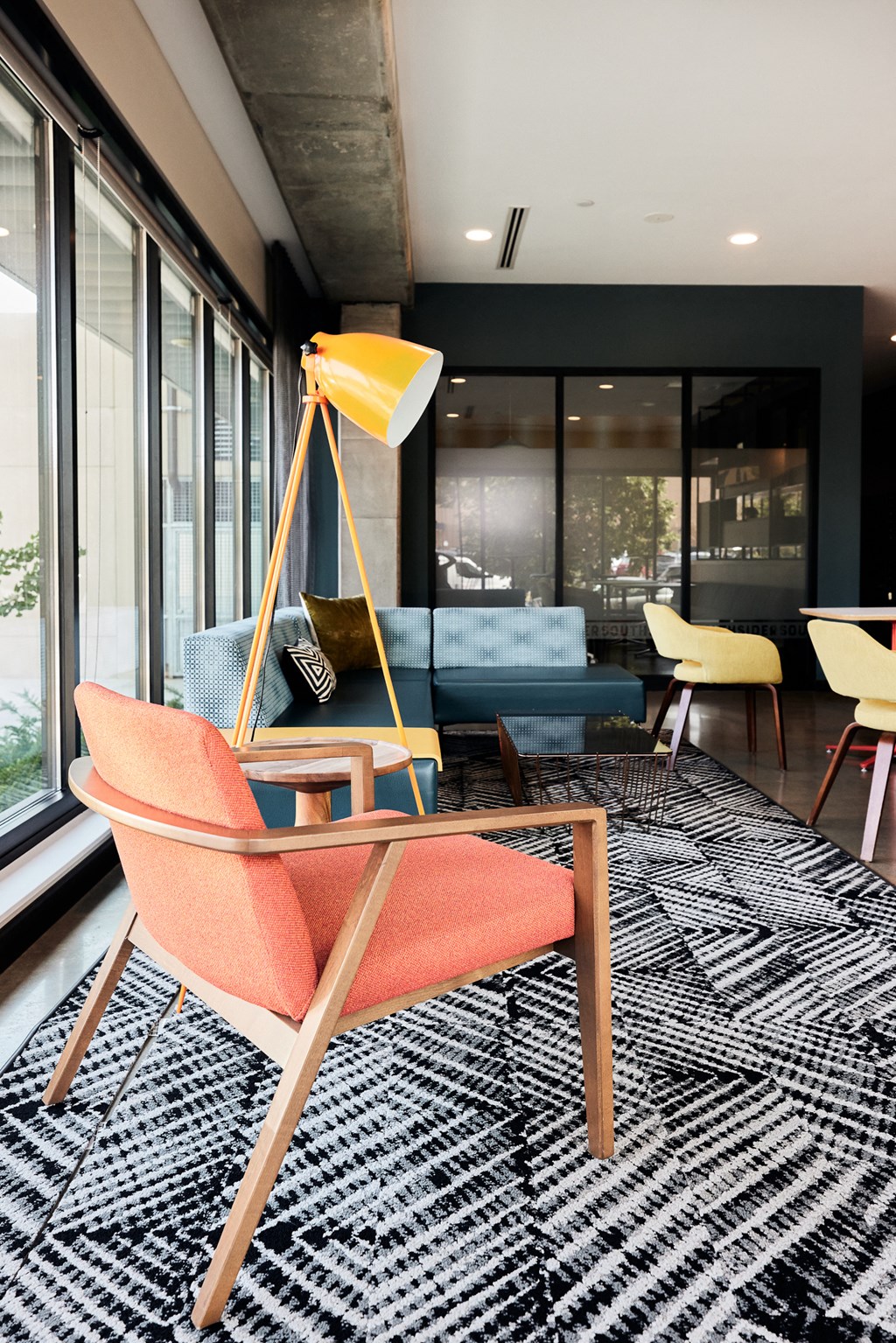 a living room with a blue couch and a yellow lamp