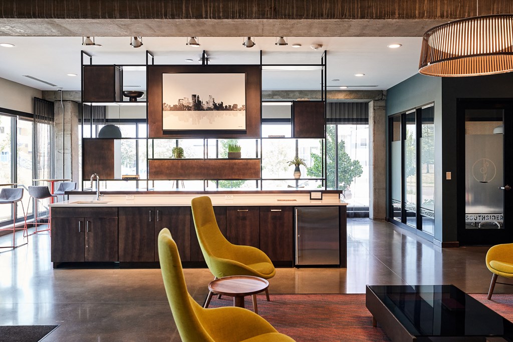 a kitchen and living room with yellow chairs and a table