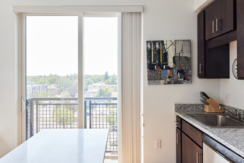 an apartment kitchen with a balcony and a door to a balcony