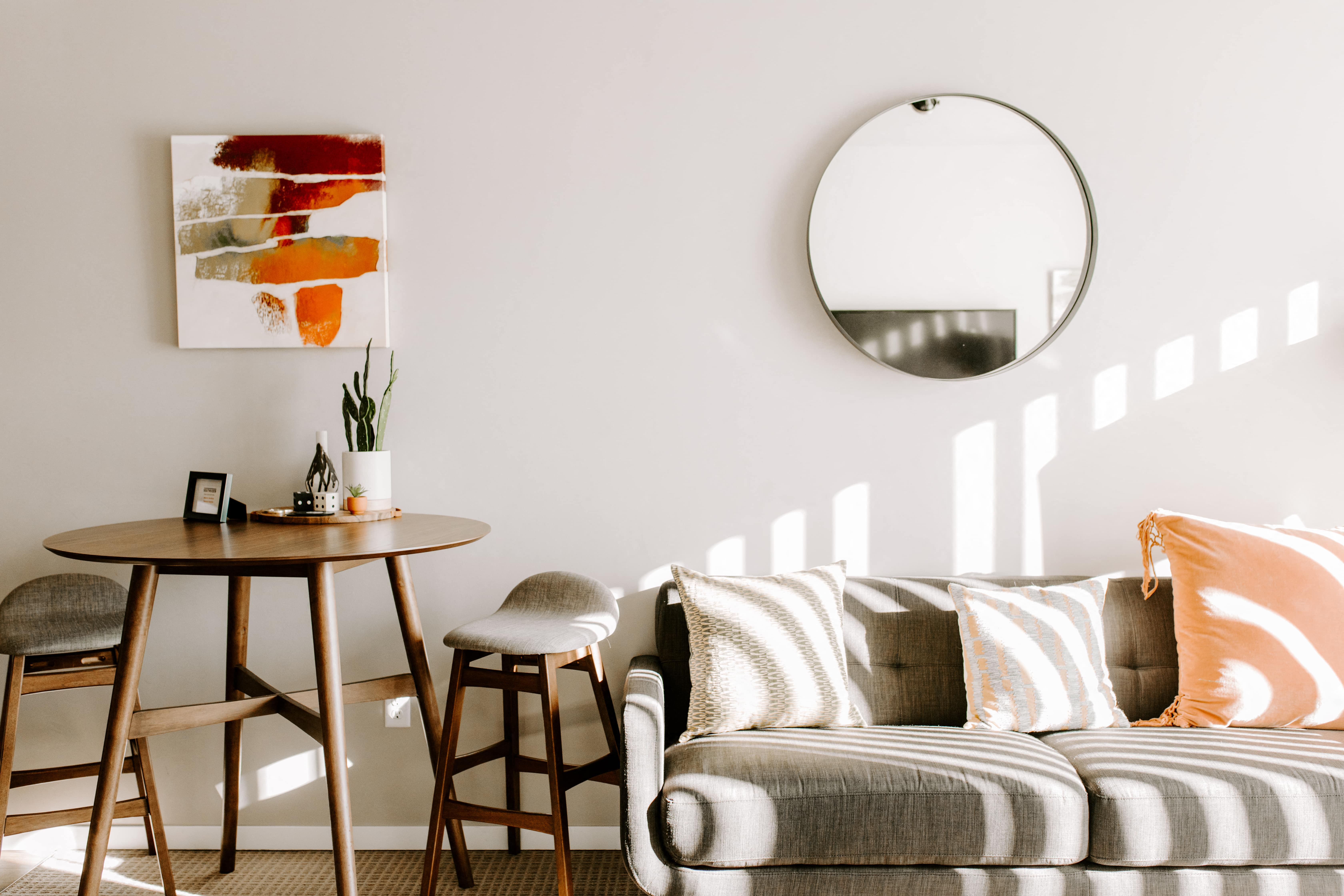 a living room with a couch and a table and a mirror