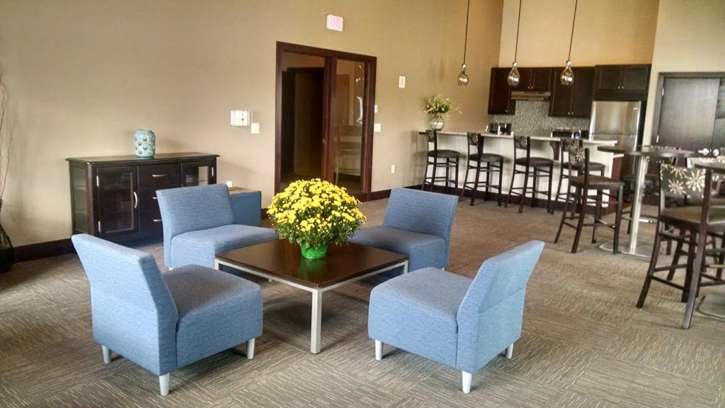 a living room with blue chairs and a table with yellow flowers