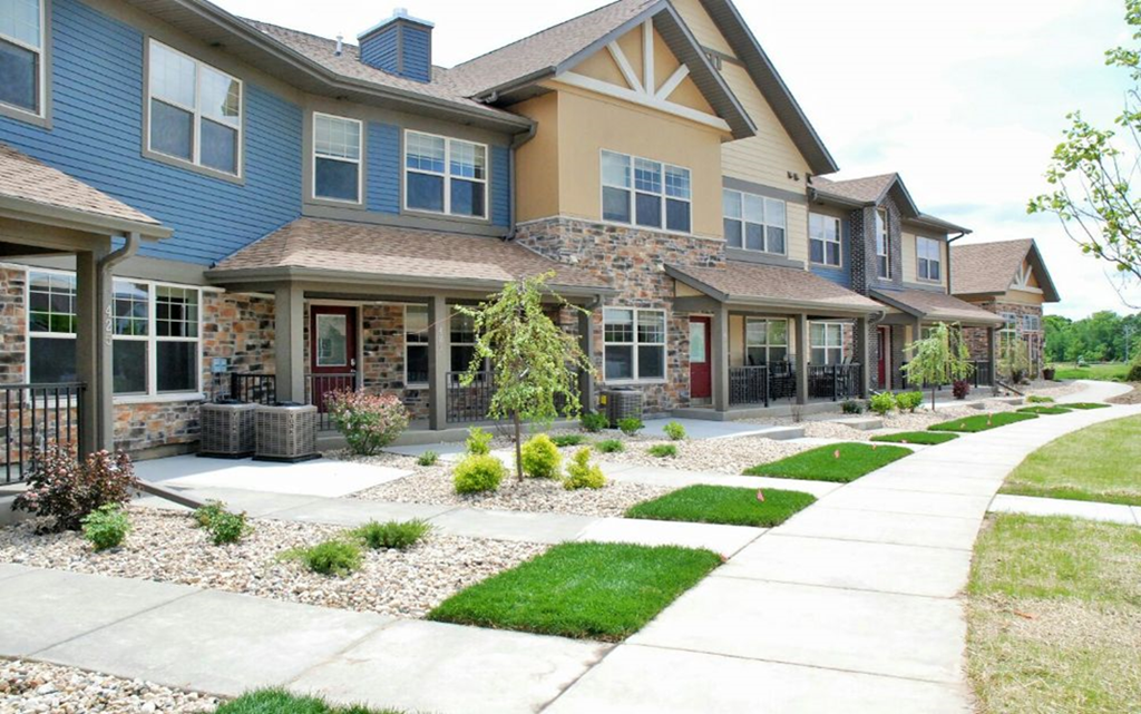 a row of houses with a sidewalk in front of them