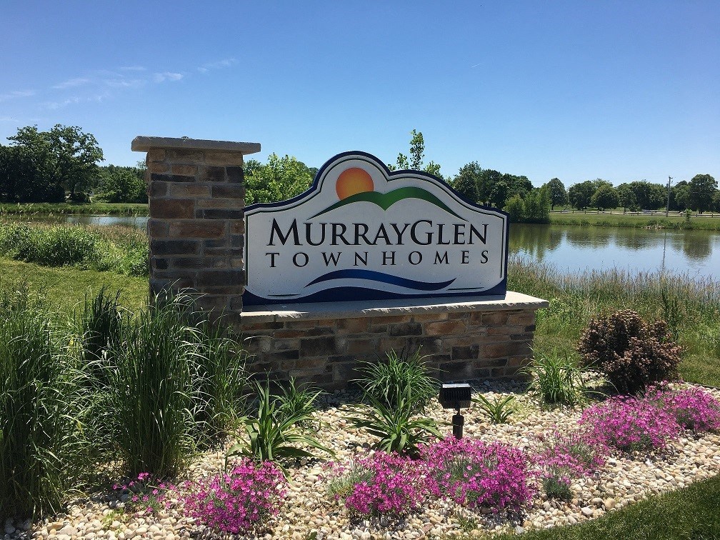 a sign town homes in front of a lake