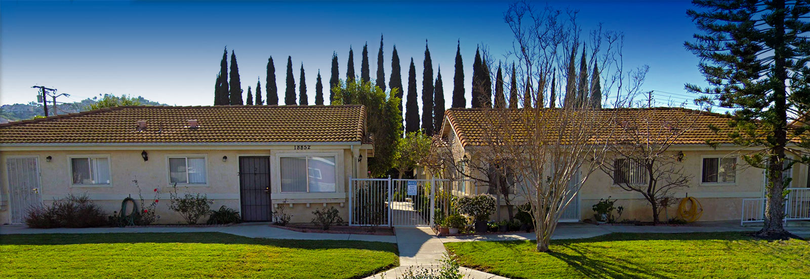 a house with a yard and trees in front of it