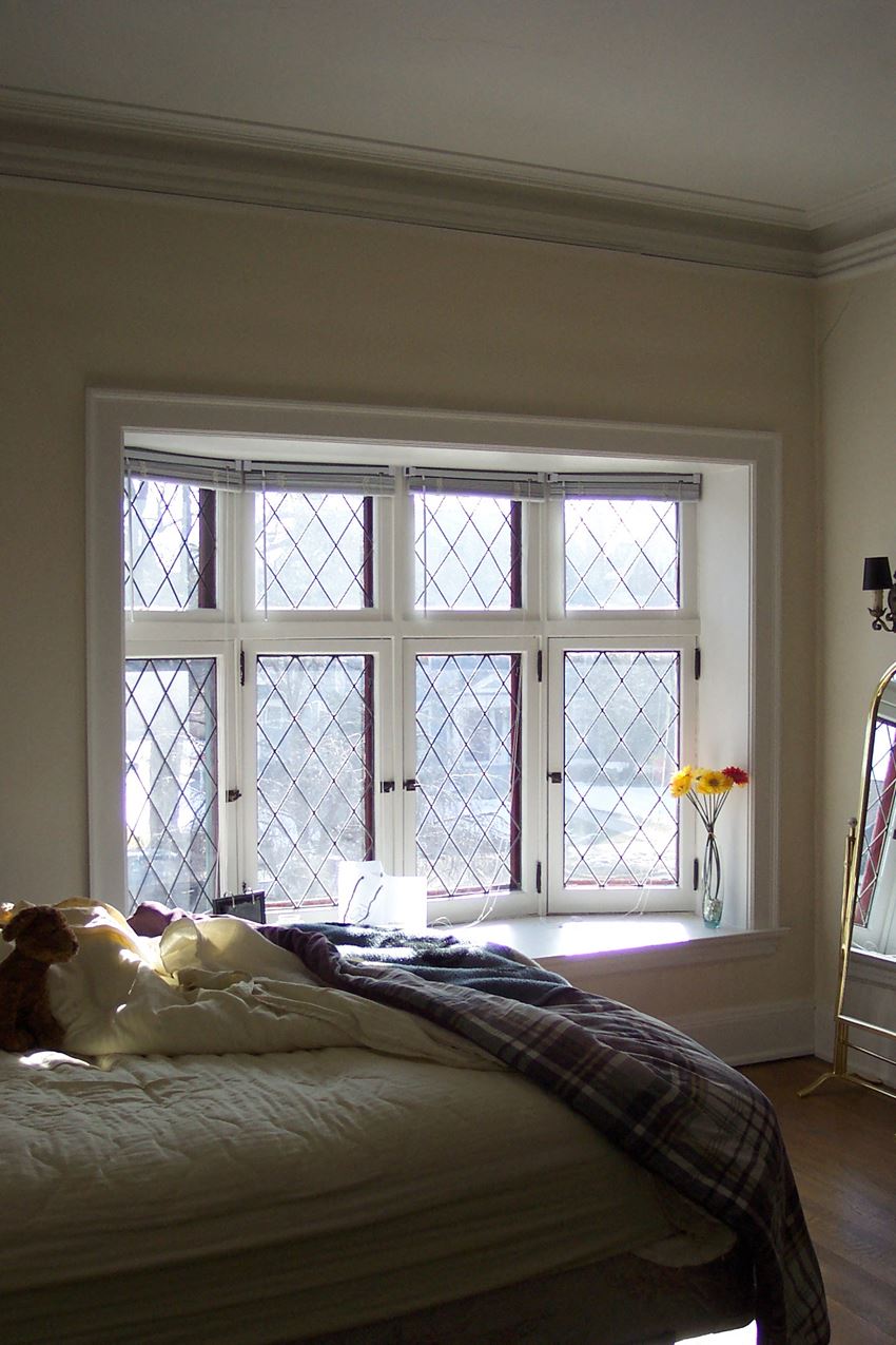 a bedroom with a bed and a large window