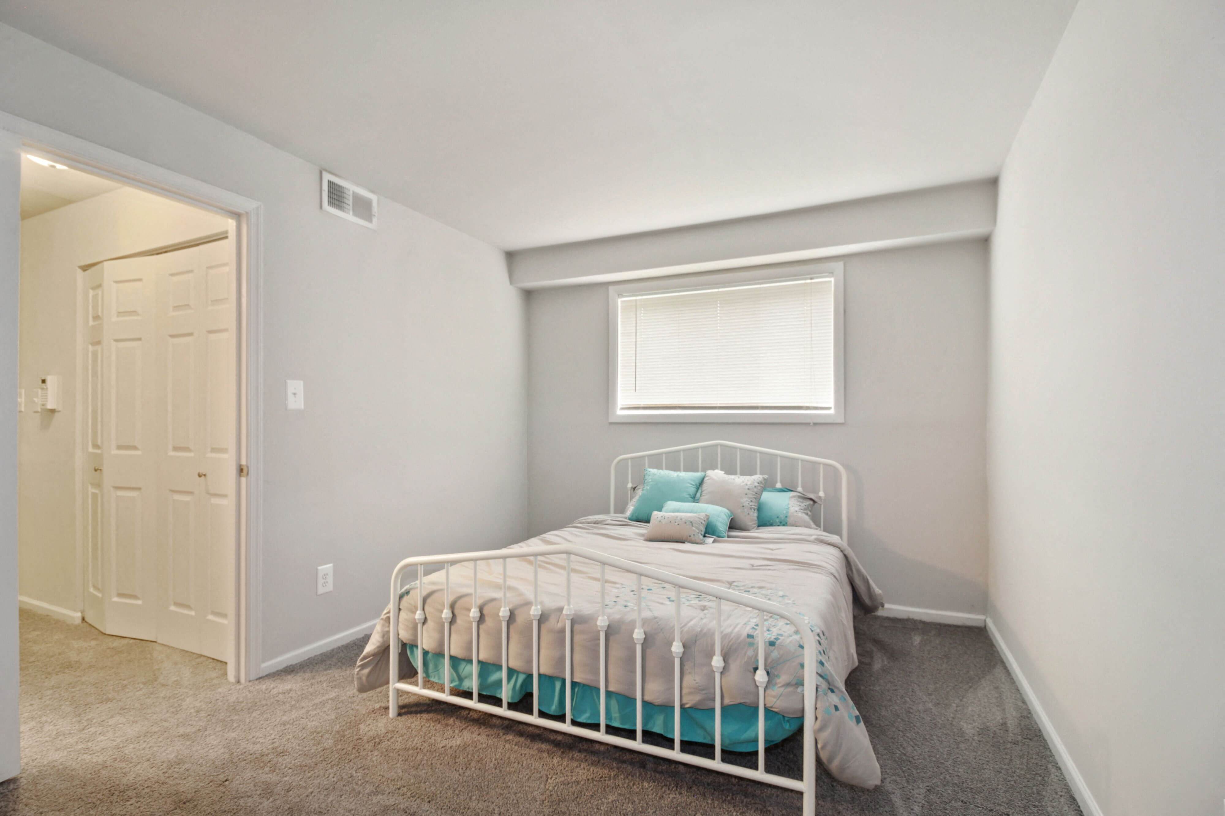 Neatly made bed with blue pillows