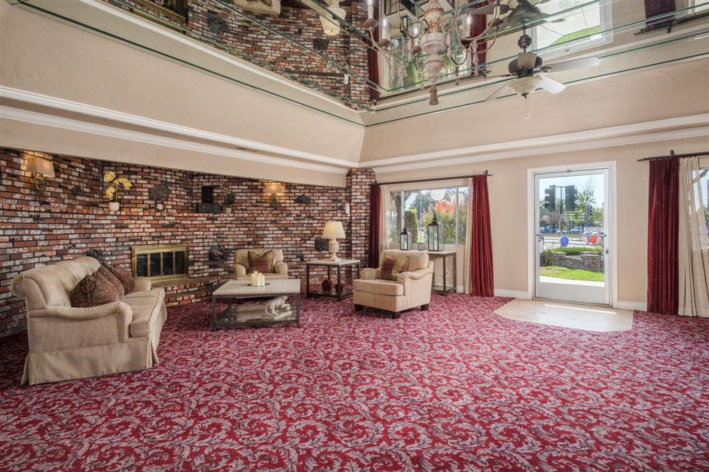 a living room with a brick wall and a red carpet