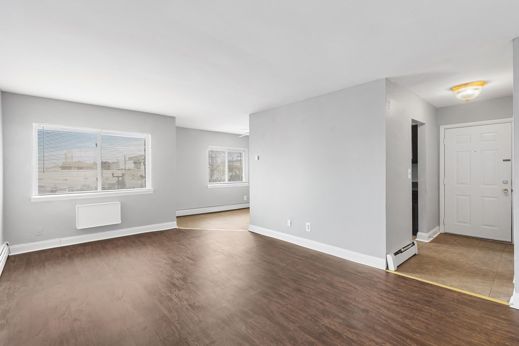 an empty living room with wood flooring and a white door