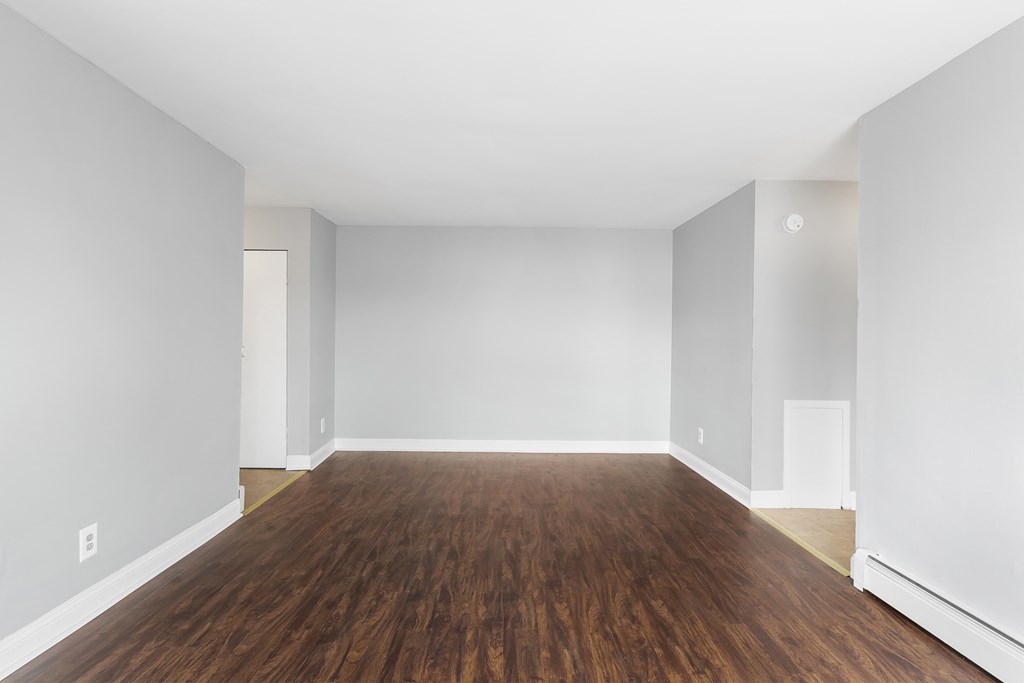 an empty room with wood floors and white walls