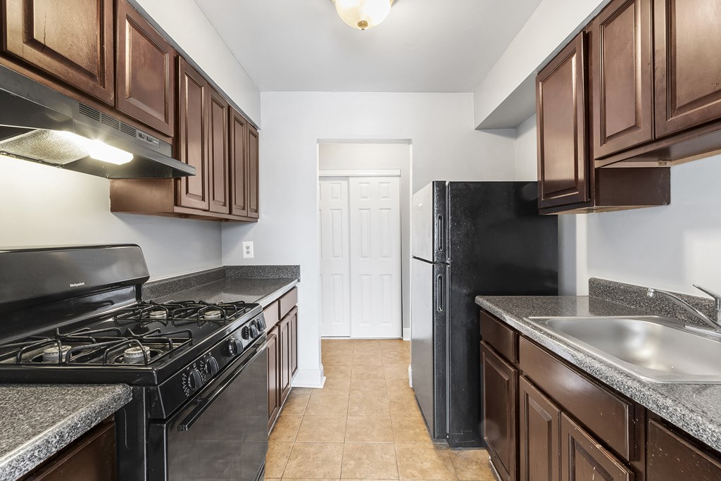 a kitchen with wood cabinets and black appliances and a black refrigerator