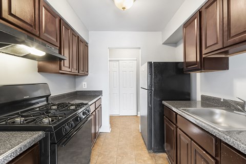 a kitchen with wood cabinets and black appliances and a black refrigerator