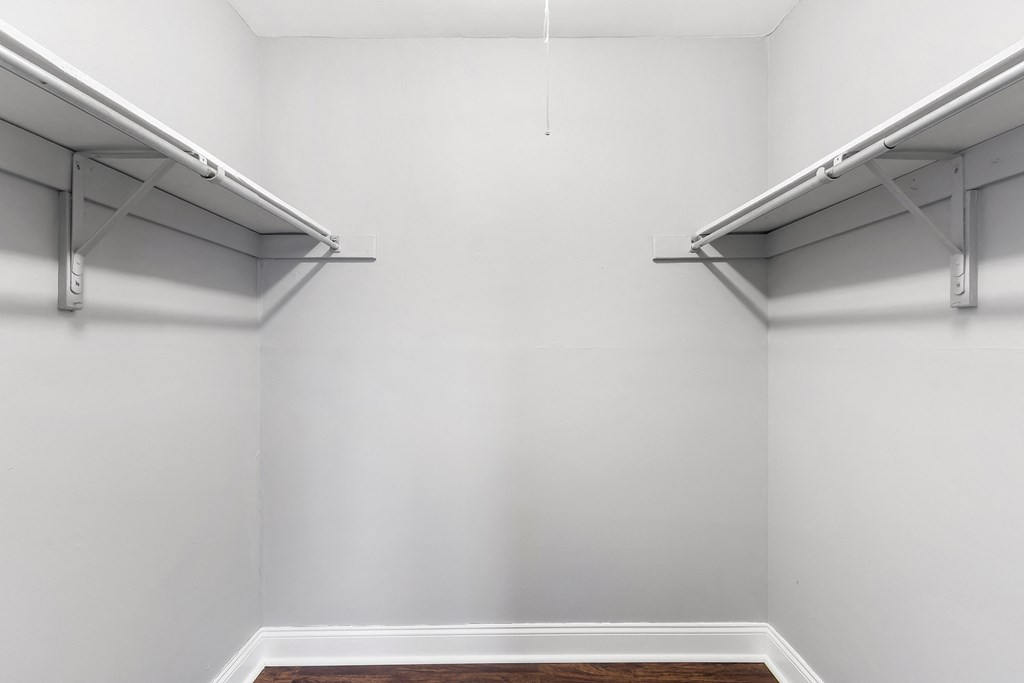 an empty room with white walls and two shelves on the wall