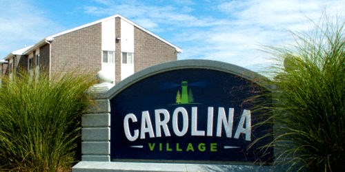 a village sign in front of a building