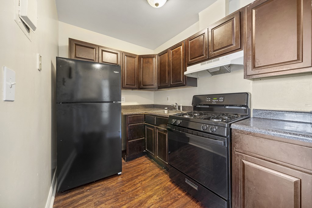 a kitchen with black appliances and wooden cabinets