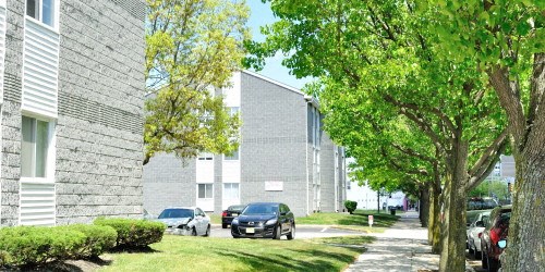 a street with cars parked in front of an apartment building