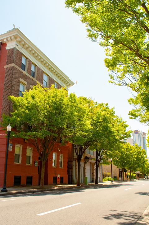 a city street with a brick building and trees