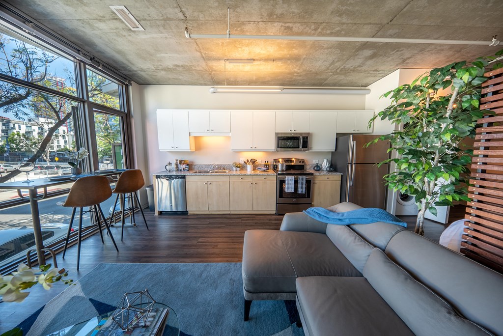 Living Room With Wood Flooring and Large Windows at 10th and G Apartments in San Diego, CA