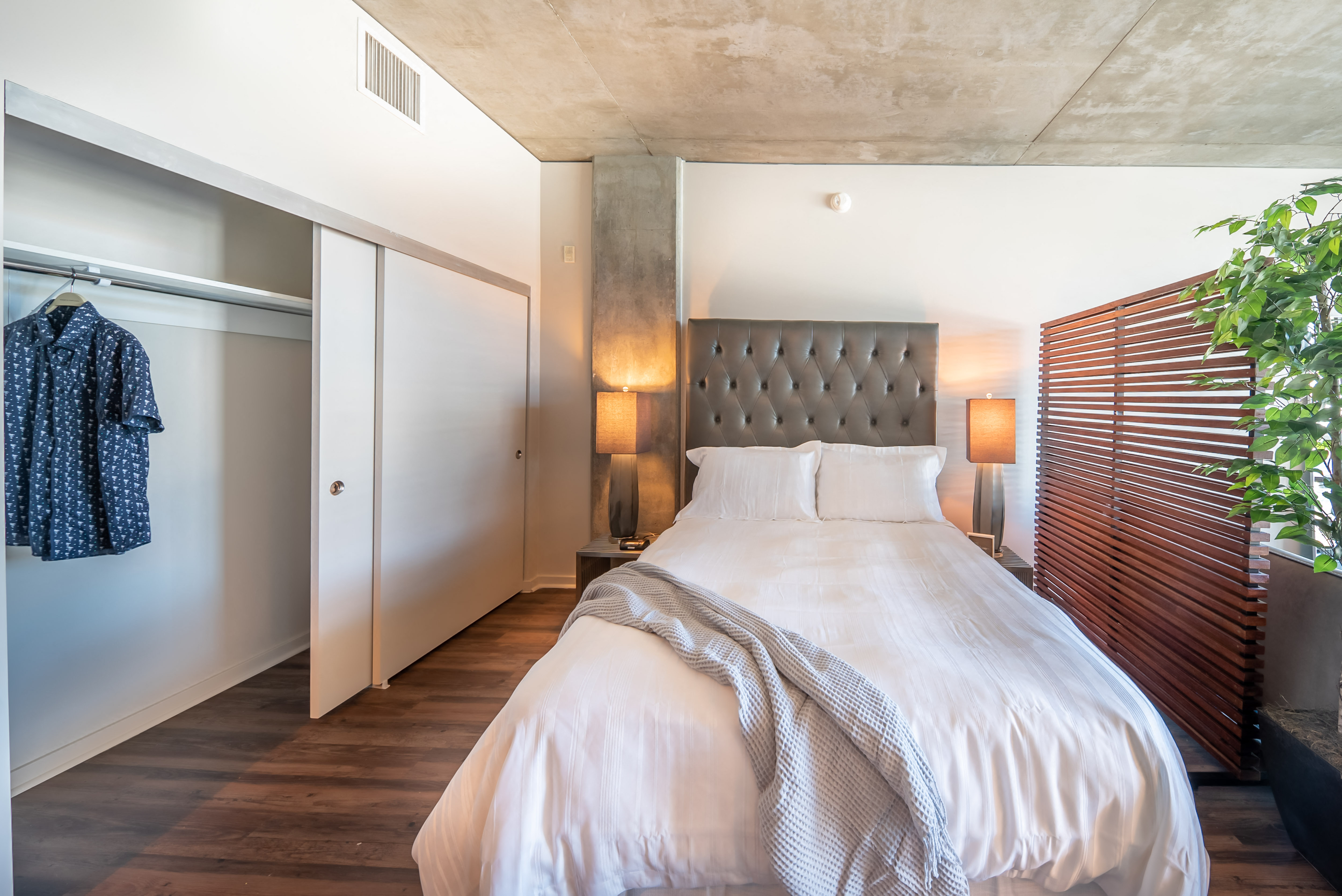 Primary Bedroom With Wood Flooring and Large Closet Space at 10th and G Apartments in San Diego, CA