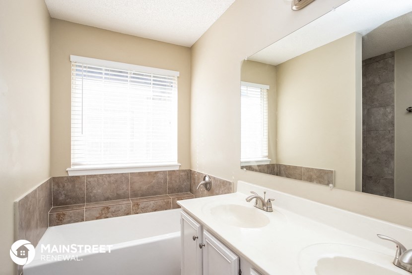 a bathroom with a tub and a sink and a mirror