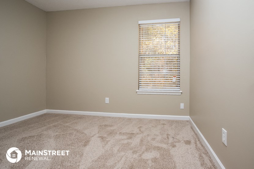 a large room with carpet and a window