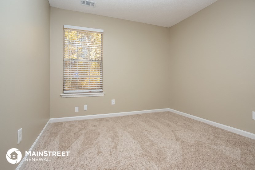 an empty room with carpet and a window