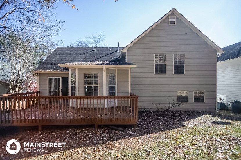 the front of a house with a porch and a deck