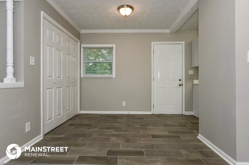 the living room of a home with a tile floor and white doors