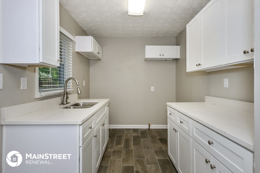 a white kitchen with white cabinets and a sink