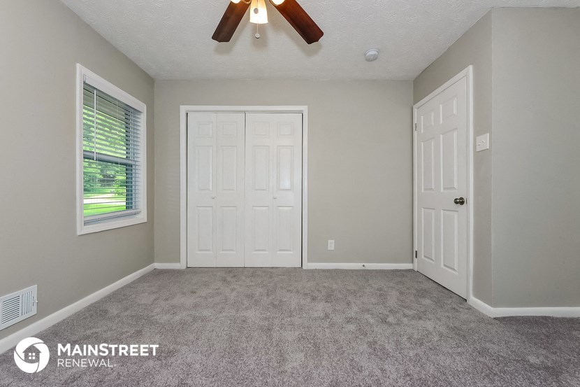 the living room of an empty house with a ceiling fan