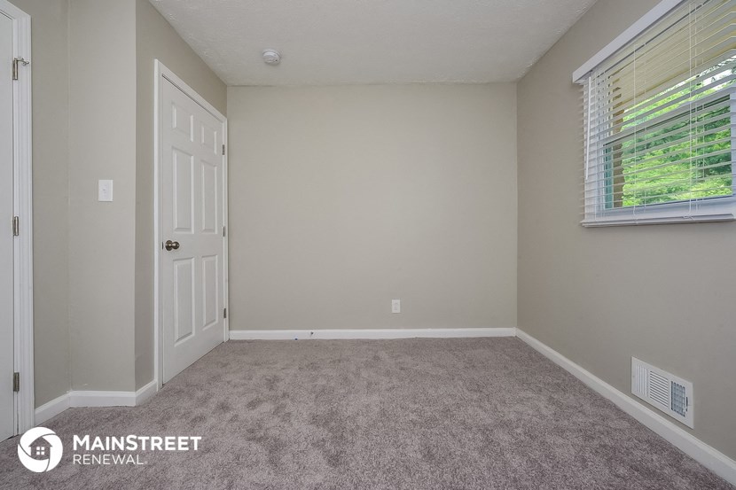 the bedroom of a home with carpet and a door