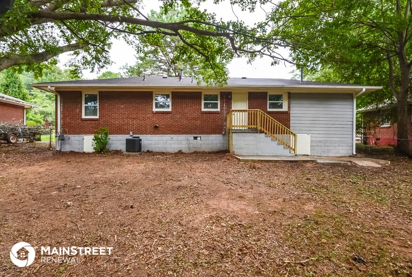 the front of a brick house with a yard and stairs