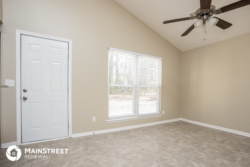 the master bedroom has a ceiling fan and a large window